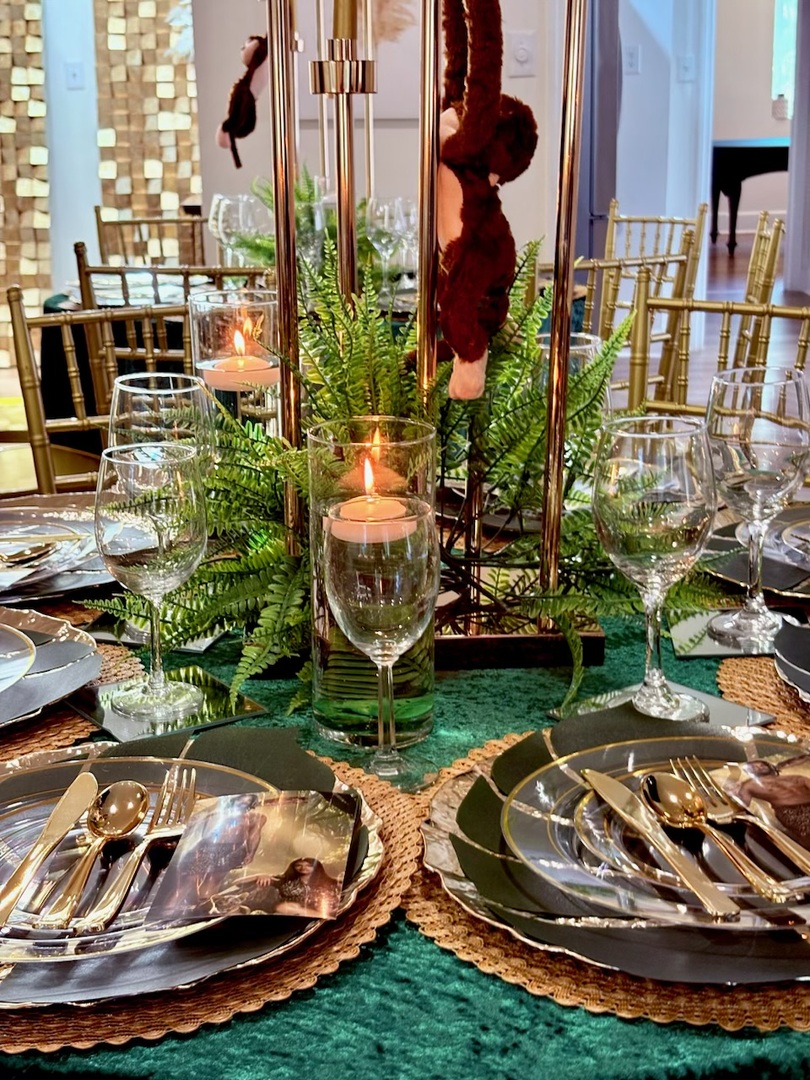Centerpiece detail with candle and greenery on a styled table